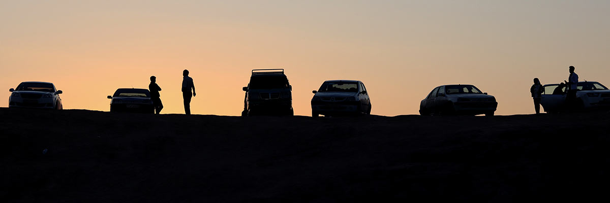 Cars and people at the sunset